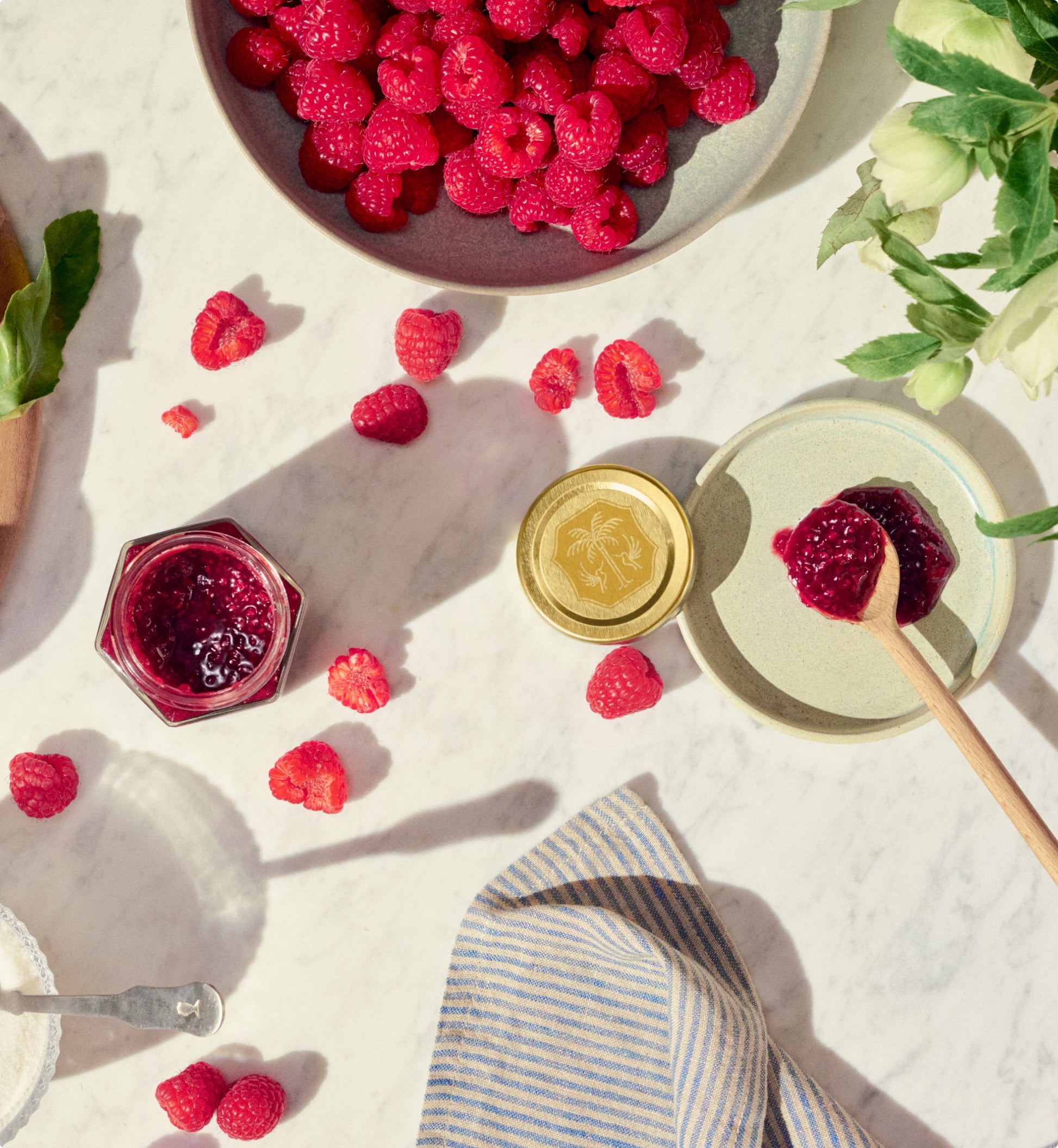 Raspberry spread on table with bowl of raspberries