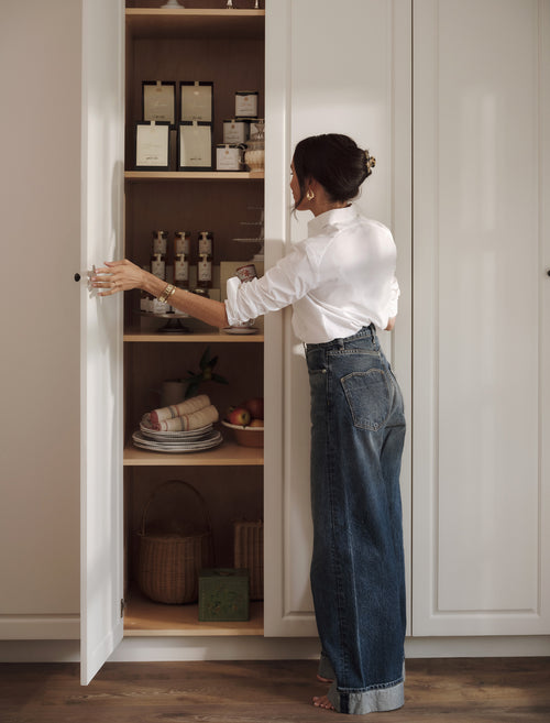 a woman reaching into a pantry