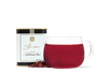 A tin of As ever tea, a clear glass of red tea, and loose dried tea leaves. 