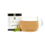 A tin of As ever tea, a clear glass of amber tea, and loose mint leaves. 