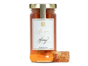 A jar of honey with a honeycomb. 