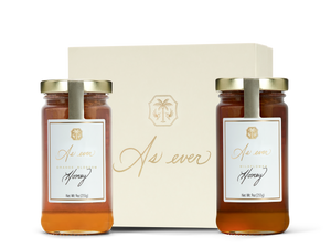 Two jars of honey in front of a beige decorative box labeled 'As ever' 