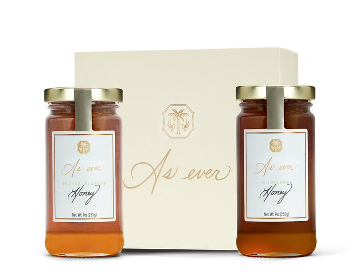 Two jars of honey in front of a beige decorative box labeled 'As ever' 