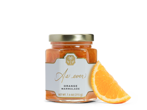A jar of orange marmalade and an orange slice. 
