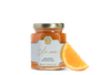A jar of orange marmalade and an orange slice. 