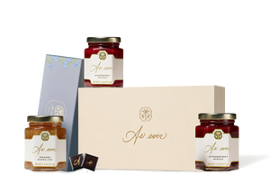 A picture of three Jars of jam in a box of chocolates. 