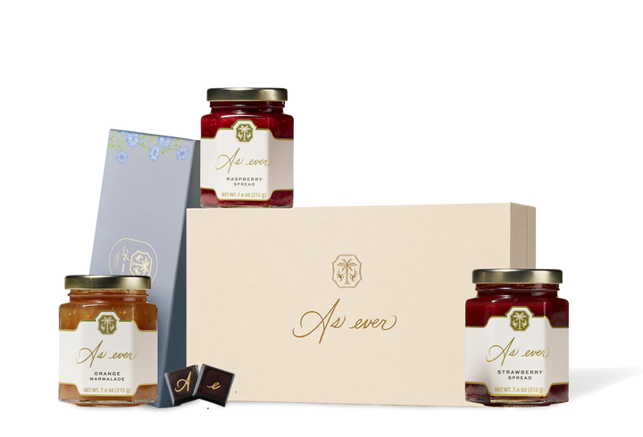 A picture of three Jars of jam in a box of chocolates. 