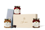 A picture of three Jars of jam in a box of chocolates. 