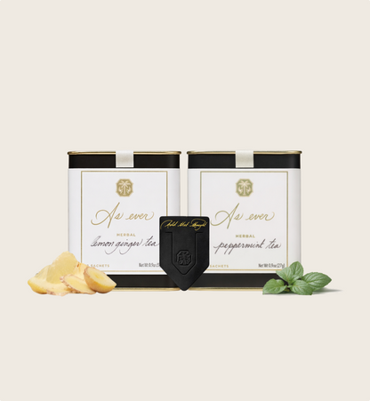Lemon Ginger Tea and Peppermint Tea Cannisters featured with a Black Leather bookmark on an off white background. 
