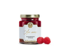 A jar of raspberry spread and two raspberries. 