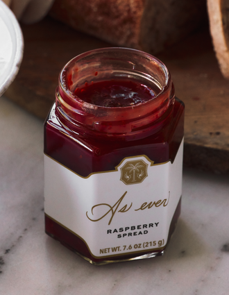 An open jar of raspberry spread 