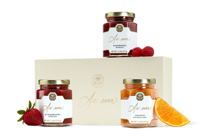 Three jars fruit spread, loose fruit, and a beige box with a gold logo.