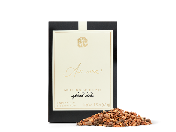 A black, beige, and gold package of mulling spice with loose spice in front of it. 