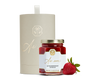 A jar of strawberry spread, a strawberry, and a beige cylindrical box with gold detailing. 