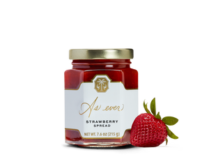 A jar of strawberry spread and a strawberry. 