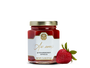 A jar of strawberry spread and a strawberry. 