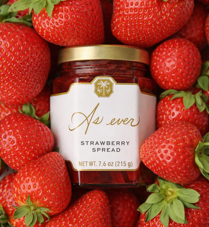 Jar of strawberry spread surrounded by fresh strawberries