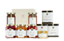 An assortment of pantry products including honeys, teas, jams, and flower sprinkles. 