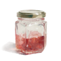 Small glass jar with a metal lid containing red jelly on a white background